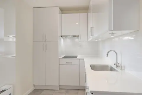A small apartment kitchen with clear, polished counters
