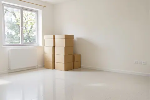 A cleared room with sorted boxes stacked neatly against one wall